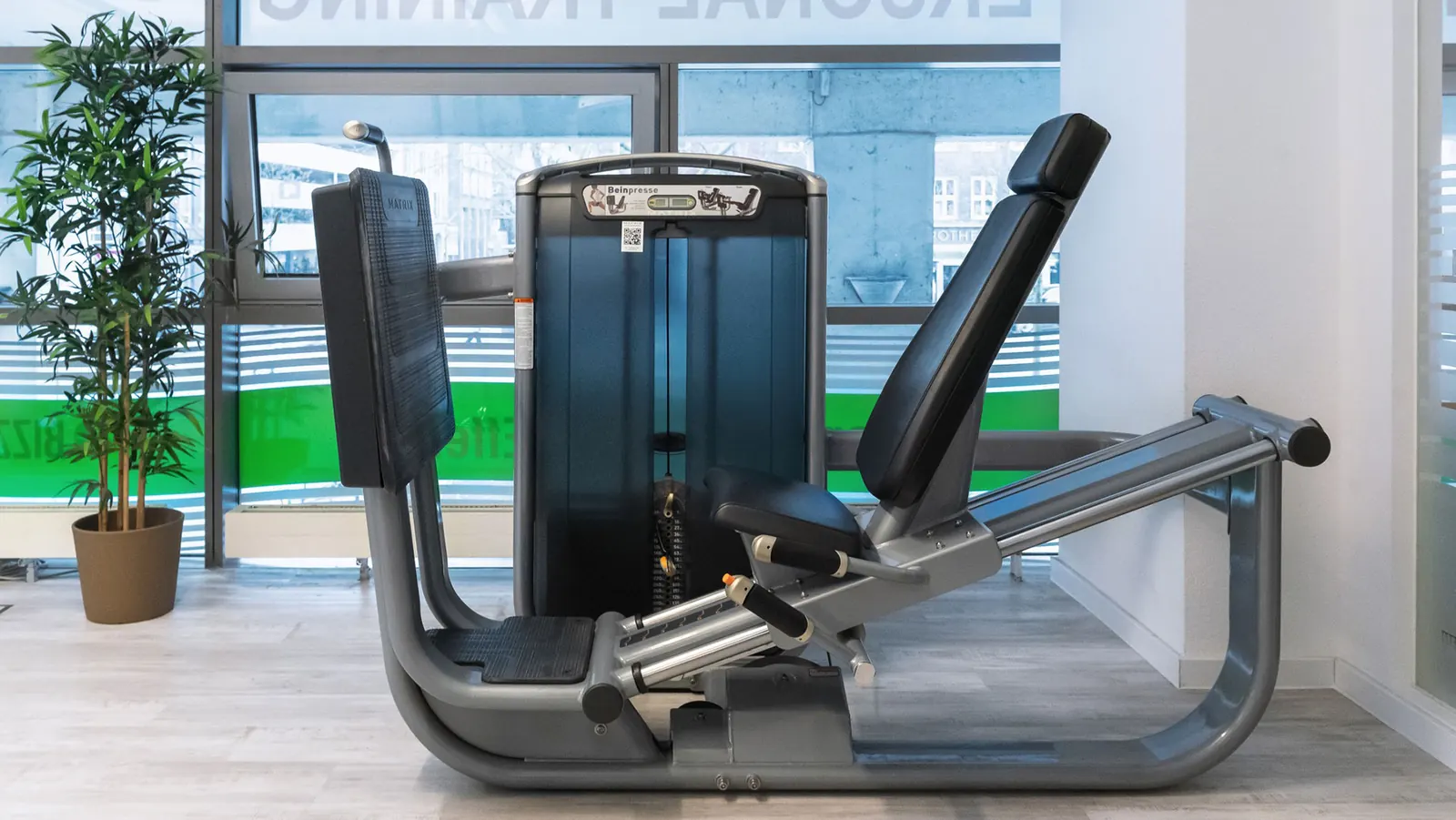 Beinpresse im Trainingsraum neben einer Zimmerpflanze